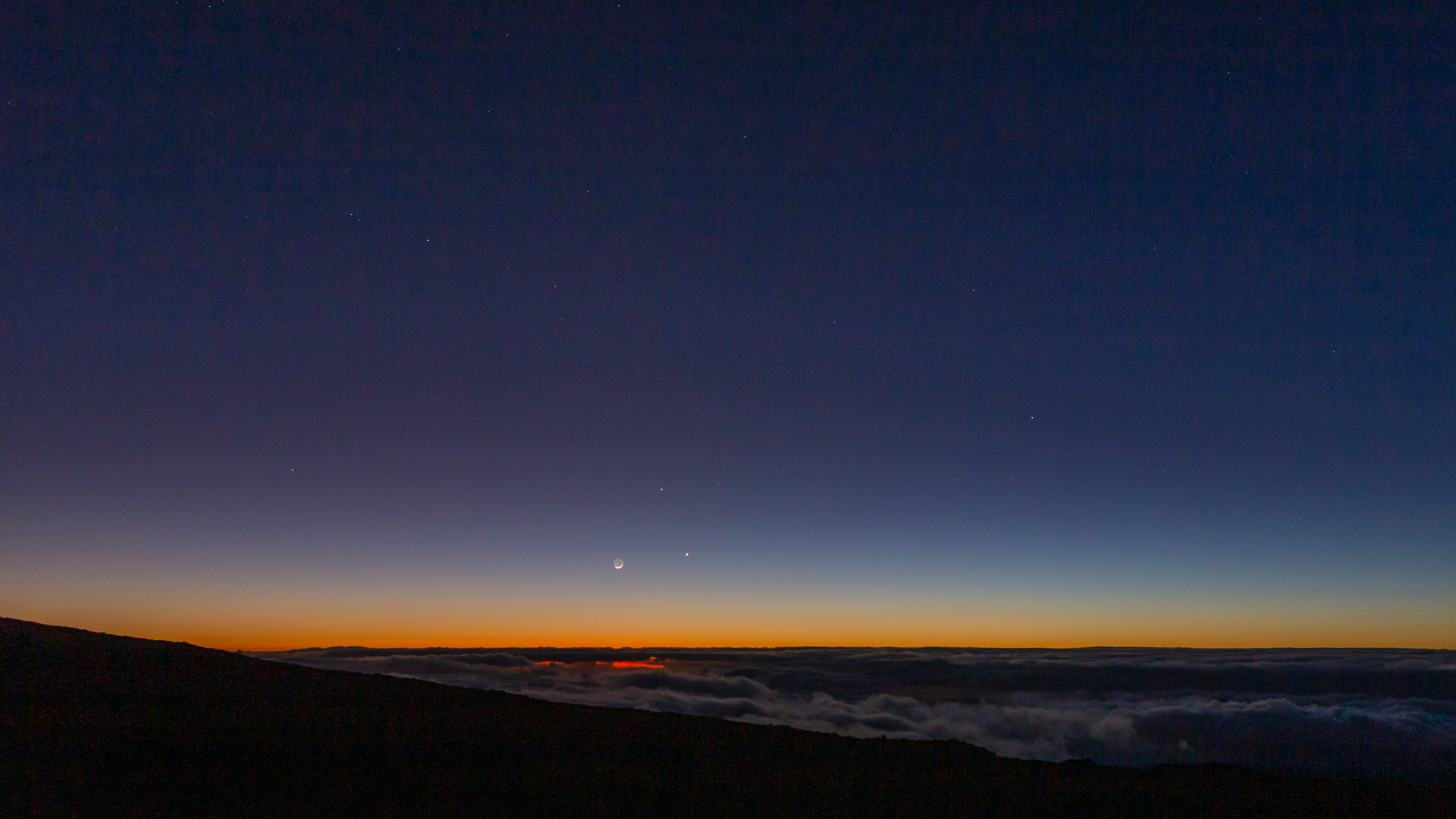 The crescent moon, Venus, and Mercury setting.